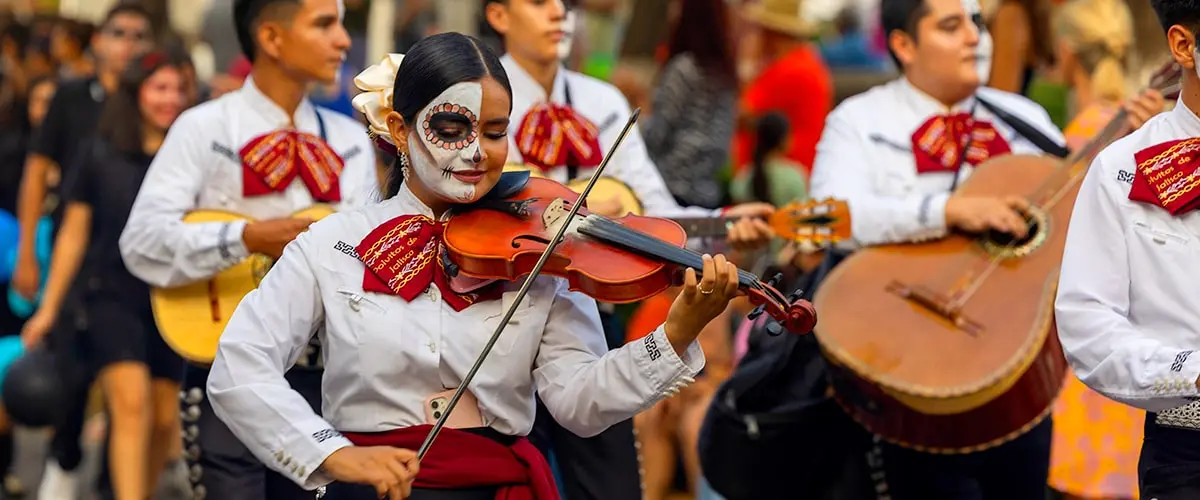 Woman in mariachi band at Day of the Dead celebration playing violin