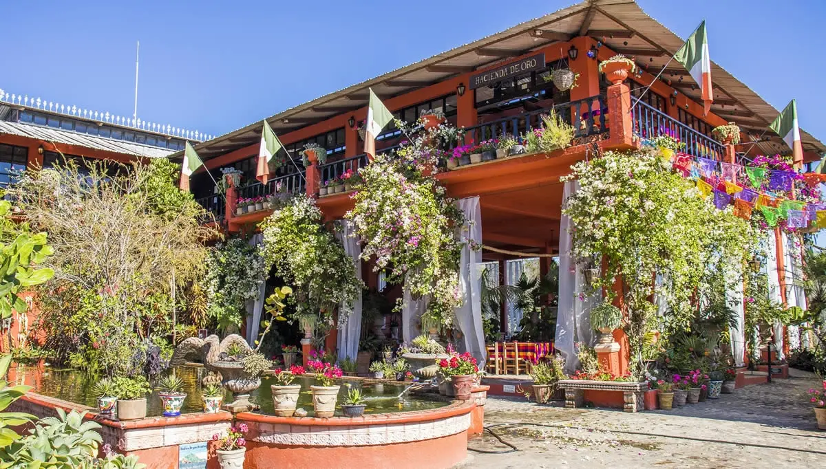 Puerto Vallarta Botanical Garden, orange building with flowers and flags.