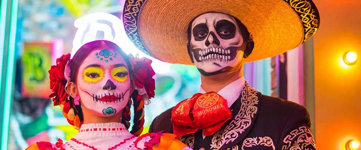 Man and woman made up as Catrina and Catrin at the celebration of the Day of the Dead