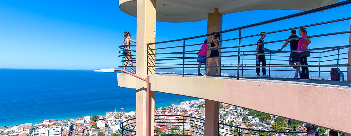 People enjoying breathtaking views of Puerto Vallarta and Banderas Bay from the Mirador de la Cruz.